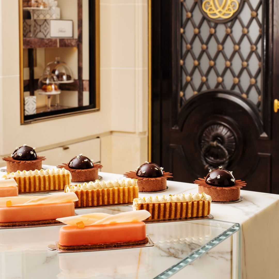Assorted pastries and desserts in a glass case and on a stand from a pâtisserie in Paris.